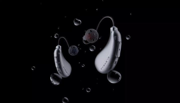 ELEHEAR behind-the-ear hearing aids with water droplets on black background, showcasing waterproof design.