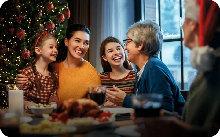 Warm family gathering at a festive dinner table, sharing happy conversations during holiday celebrations.