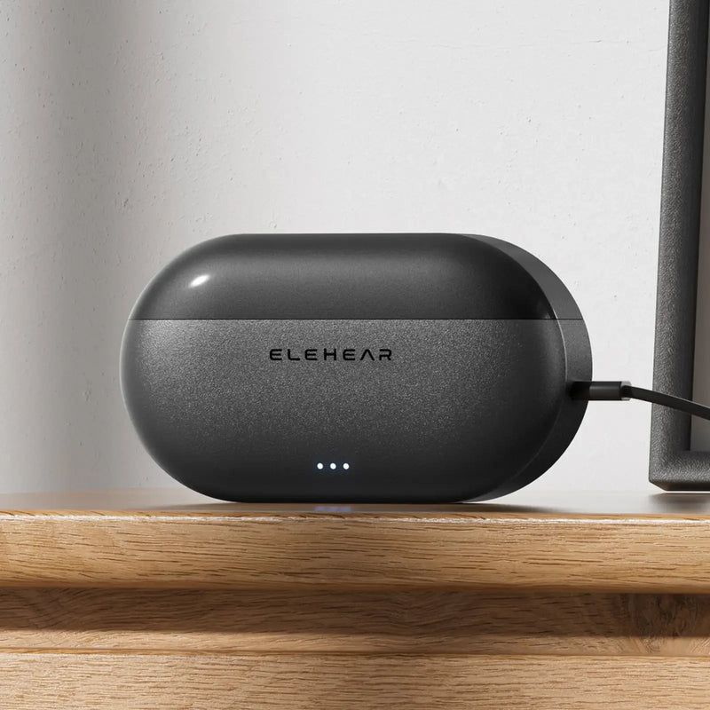 ELEHEAR hearing aid charging case with USB-C cable on wooden desk showing rechargeable battery system