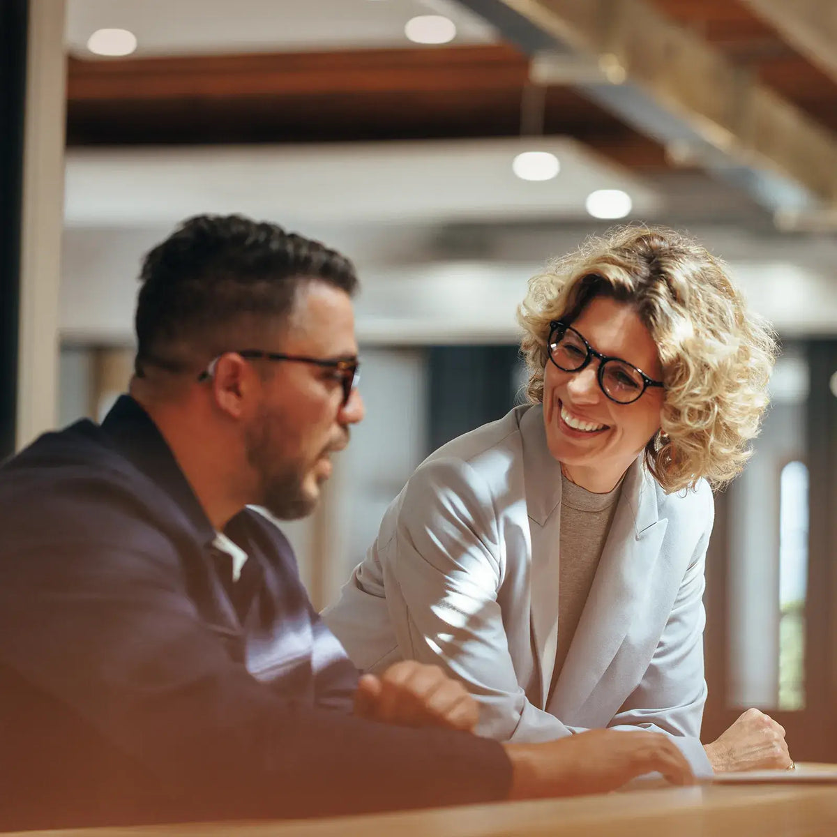 People talking in a busy office setting while wearing hearing aids