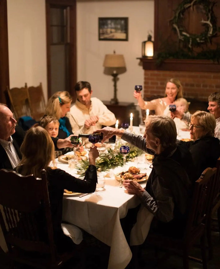 Family gathering around a dining table with Christmas decorations.