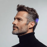 Man wearing modern behind-the-ear hearing aid with blue LED indicator light, profile view showing discreet digital hearing device thumbnail