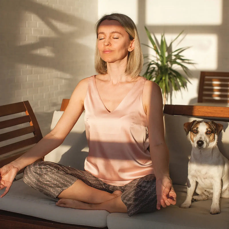 Woman meditating peacefully with dog using hearing aids with tinnitus masking feature for sound therapy